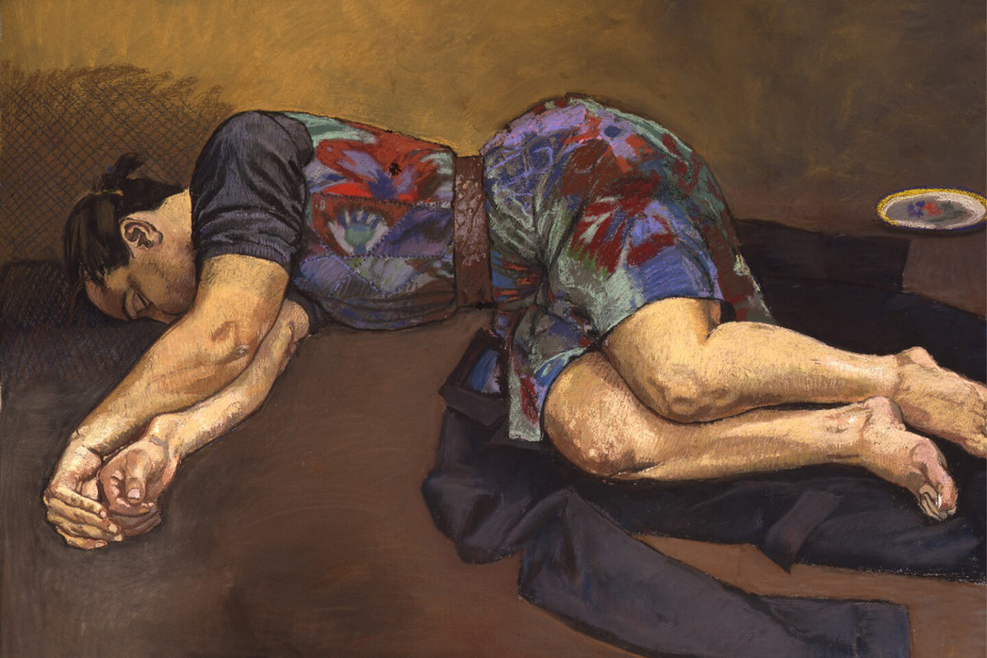Frau im geblümten Kleid liegt auf dem Boden auf der Seite auf einem Jackett. Arme von sich gestreckt. schläft, seitliche Position