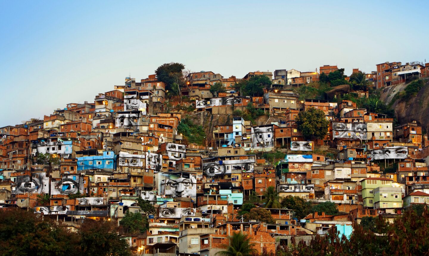 JR – der französische Streetart Künstler 
Favela, Rio de Janeiro, äugen und Gesichter auf Hauswände plakatiert
