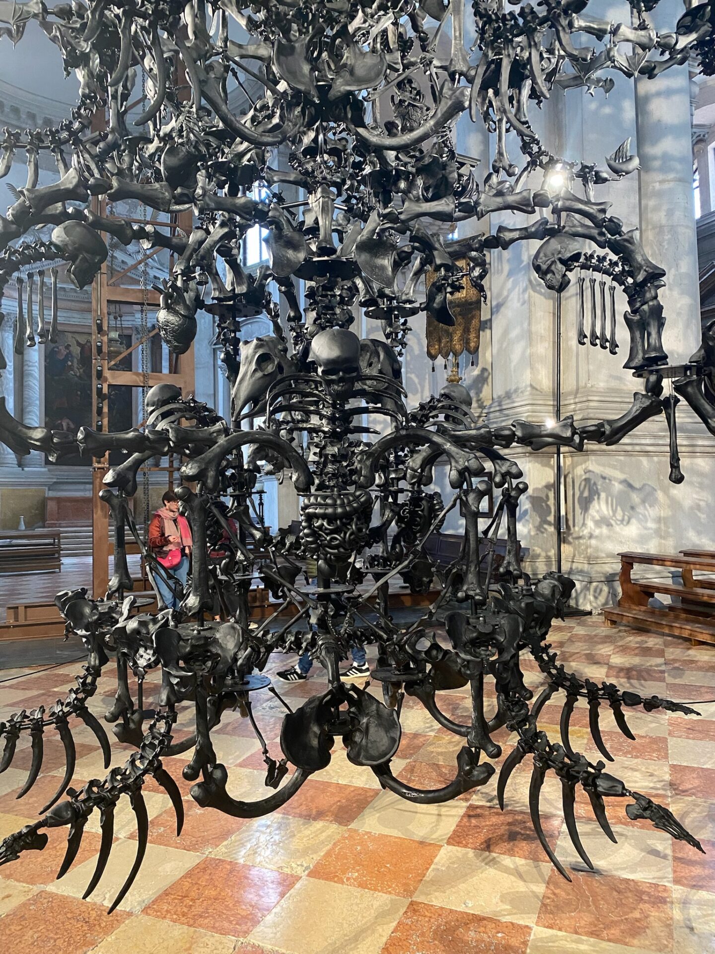 Ai Weiwei, La Commedia Umana, 2022, Installation in San Giorgio Maggiore, schwarzer Glasleuchter, Muranoglas, Kronleuchter, Knochen, Totenköpfe aus Glas