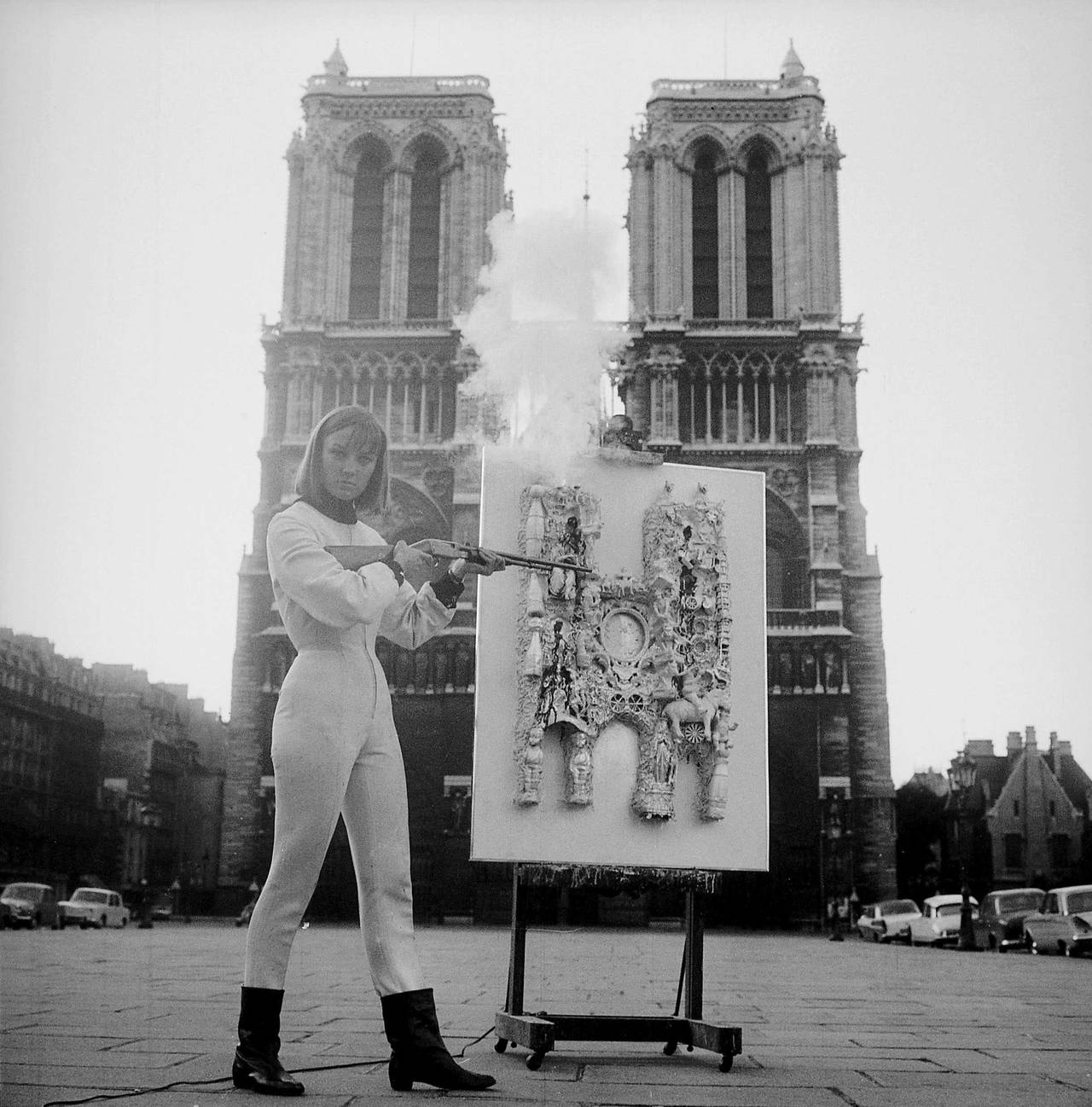 Niki de Saint Phalle bei der 800-Jahr-Feier von Notre-Dame in Paris mit einer Schießaktion, 1963, weißer Anzug, Gewehr, Assemblage auf Staffelei 