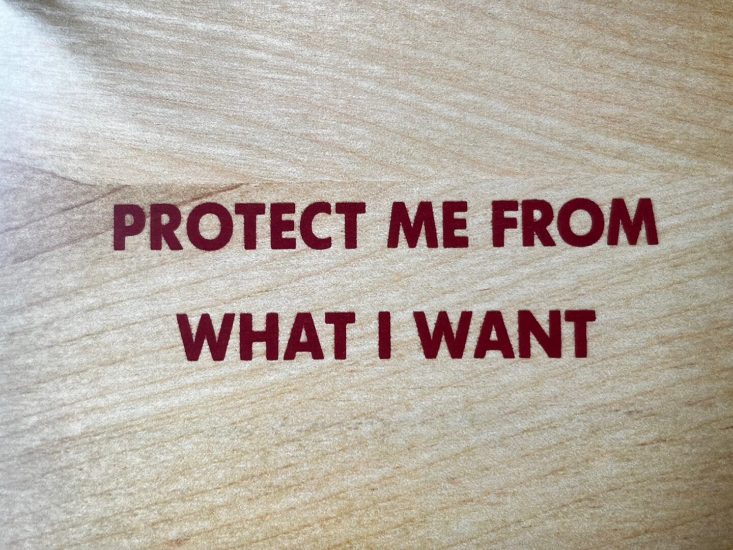 Sprachgewaltig und gesellschaftskritisch: Jenny Holzers Textkunst. protect me from what I want, beschütze mich vor dem was ich will. Schrift in rot auf holz